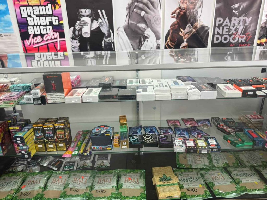 Display case in a cigarette shop Houston featuring vapes, e-liquids, kratom, and tobacco products for diverse customer preferences.