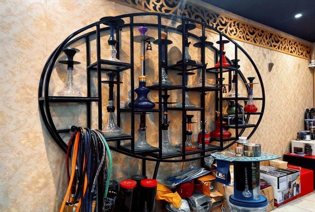 Stylish wall-mounted hookah rack with premium models and hoses at hookah shop Houston.