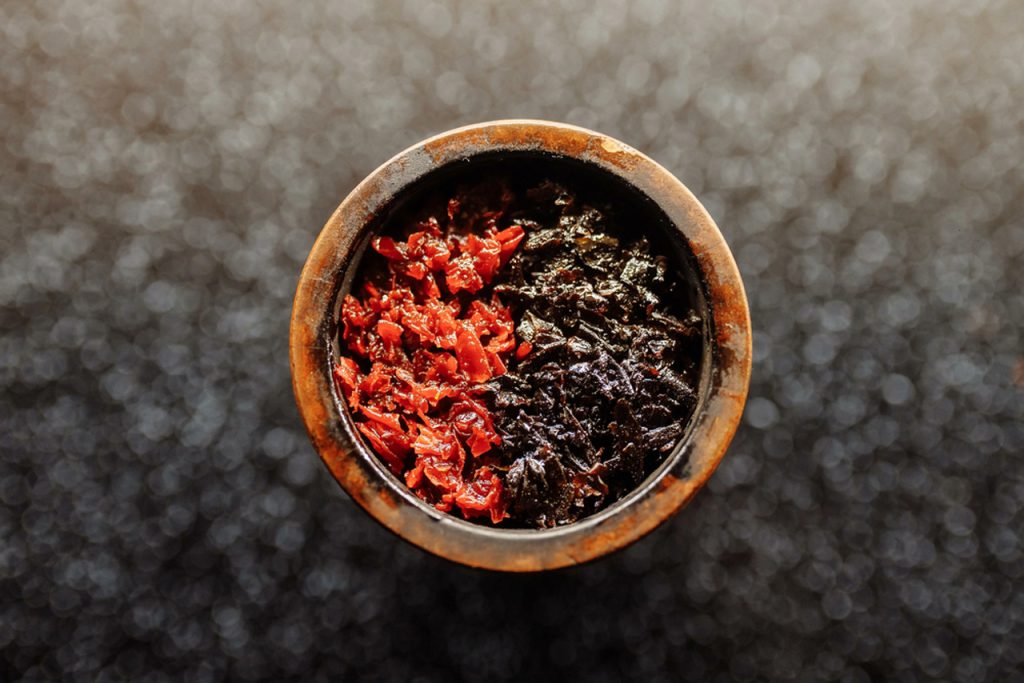 Close-up of a hookah bowl packed with vibrant red and dark shisha tobacco flavors, ready for smoking at a premium tobacco shop in Houston.