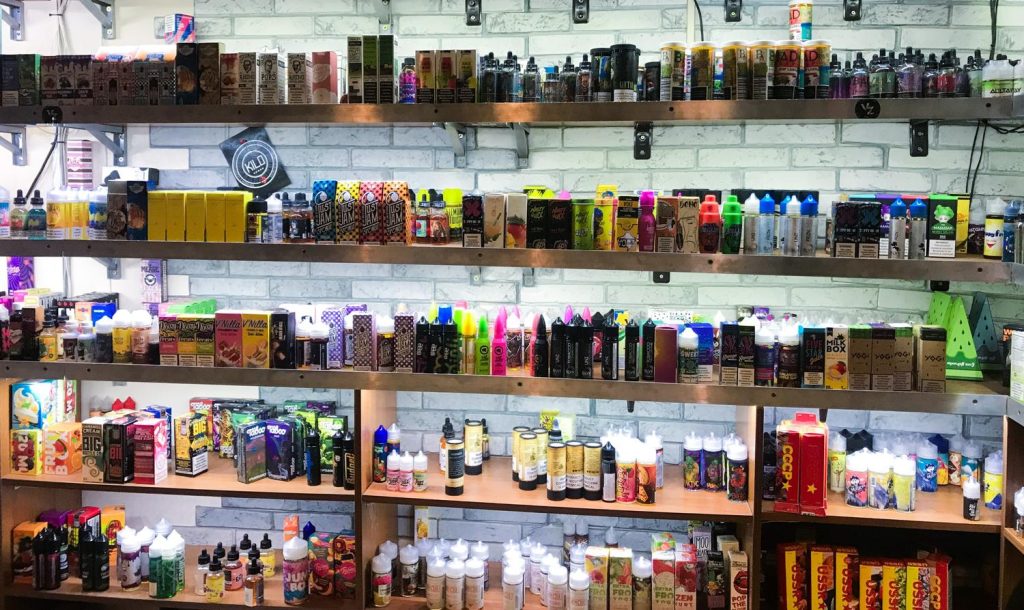 Vape juices displayed on shelves in a smoke shop in Houston, offering a variety of flavors.