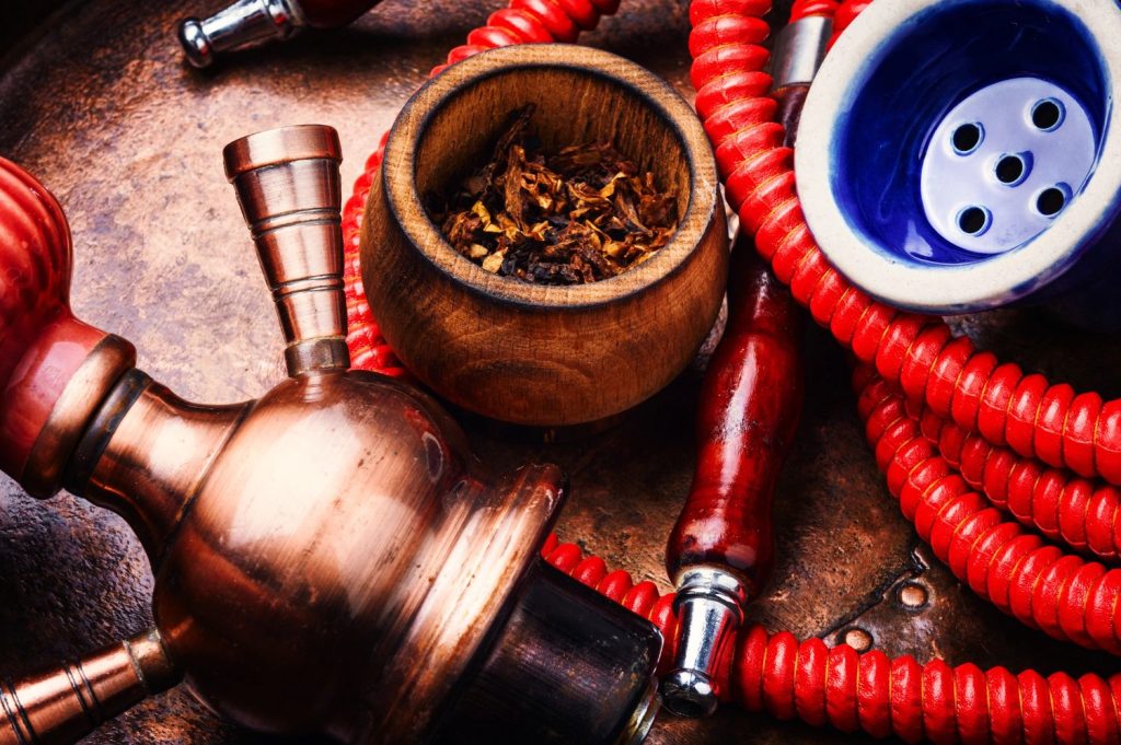 Hookah with tobacco and red hose at a tobacco shop in Houston, ready for use.