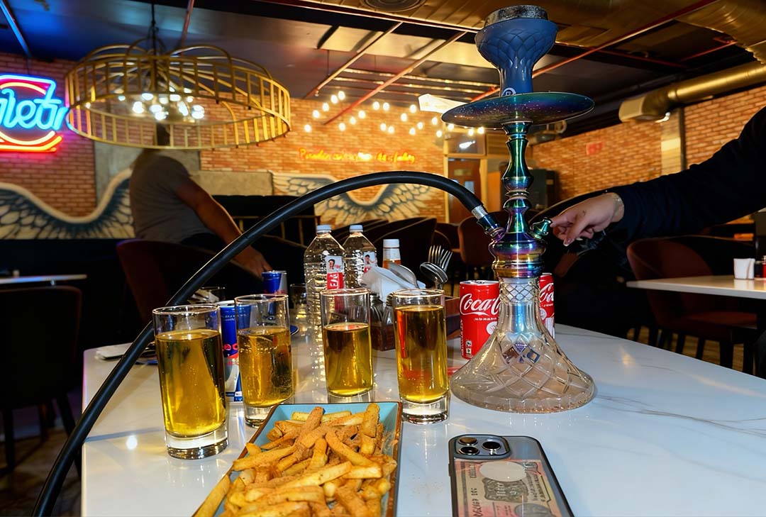 Thick smoke clouds from glowing hookah in upscale lounge at hookah shop Houston.