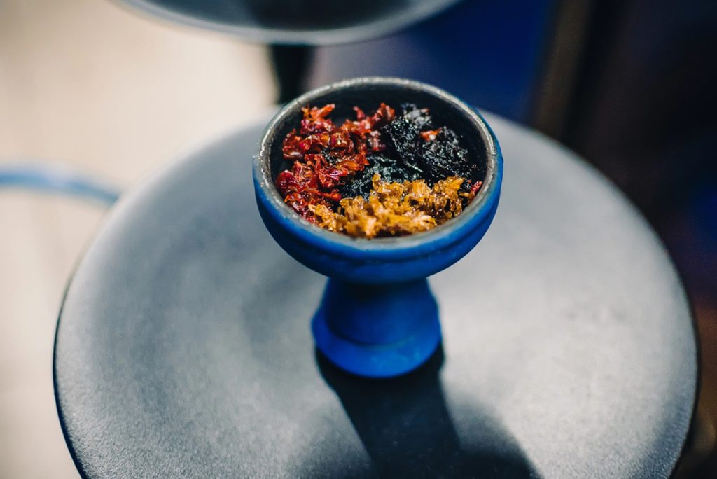 Blue hookah bowl topped with colorful layered shisha tobacco mixes including red, black, and blonde, available at Houston's top tobacco shop.