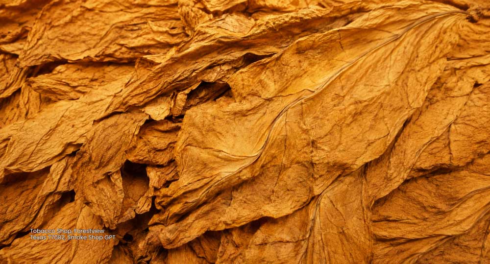 Detailed texture of cured whole golden tobacco leaves, representing quality stock at our tobacco shop Houston area.
